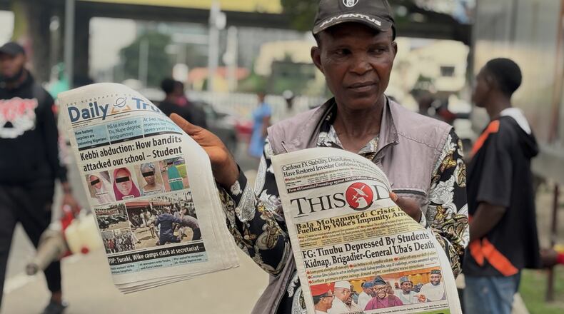 A vendor display local newspapers on the street of Lagos with headlines of the Government Girls Comprehensive Secondary School, where gunmen on Monday attacked the school dormitory, abducted schoolgirls, in Kebbi Nigeria, Wednesday, Nov. 19 2025. (AP Photo/Sunday Alamba )