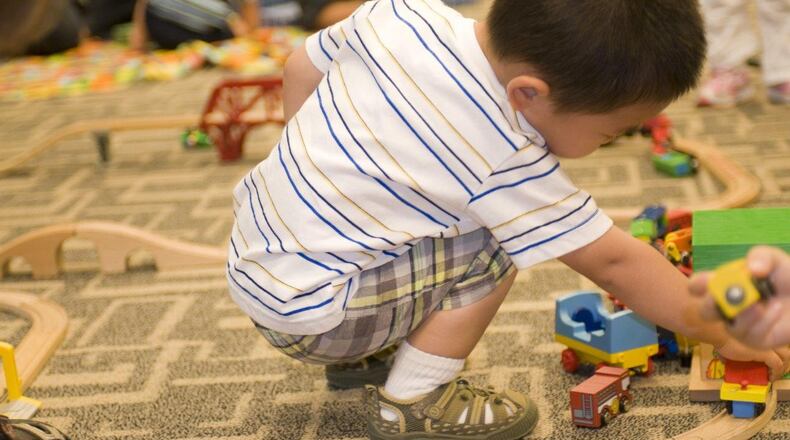 While in a daycare setting, this young boy was entertaining himself by playing with a small wooden toy car set, pushing the little cars along the grooved wooden track. CDC HANDOUT