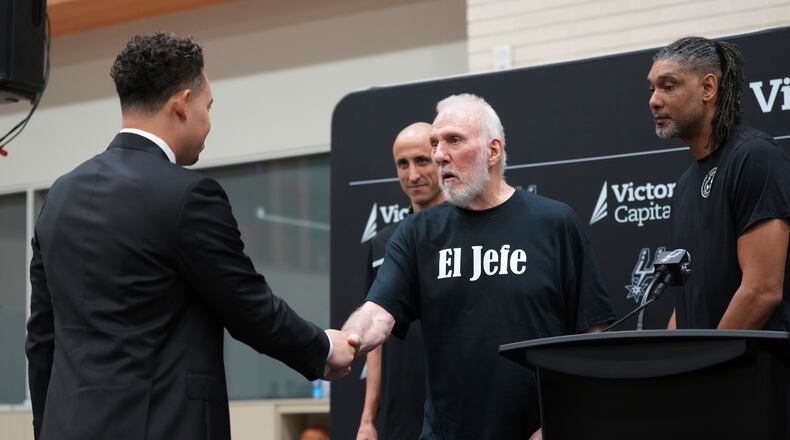 FILE - With the help of former players Manu Ginobili, back left, and Tim Duncan, right, former San Antonio Spurs head coach Gregg Popovich, center, introduces Mitch Johnson, left, as the new head coach of the San Antonio Spurs NBA basketball team, in San Antonio, May 5, 2025. (AP Photo/Eric Gay, File)