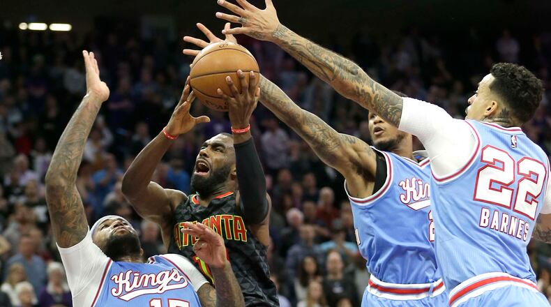 Atlanta Hawks guard Tim Hardaway Jr., second from left, goes to the basket between Sacramento Kings forward DeMarcus Cousins, left, Ben McLemore, third from left, and Matt Barnes, right, in an attempt to make the game winning shot in the final moments of an NBA basketball game Friday, Feb. 10, 2017, in Sacramento, Calif. (AP Photo/Rich Pedroncelli)