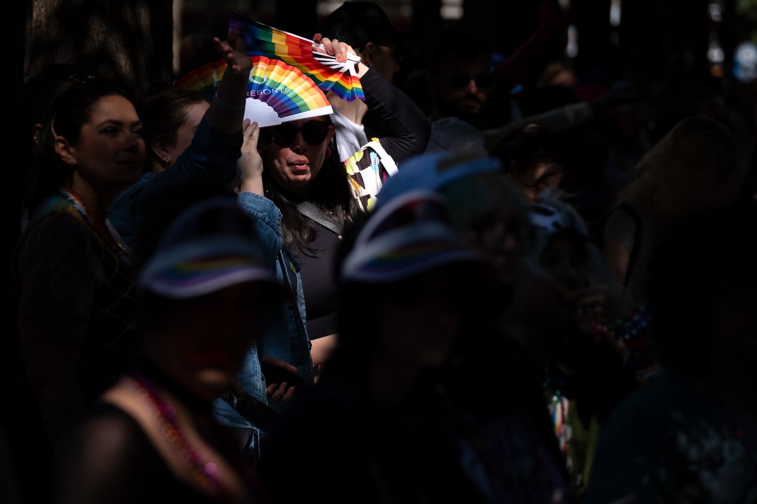 Nicole Parker uses a rainbow fan to keep the sun out of her eyes while watching the Atlanta Pride Parade on Sunday, Oct. 12, 2025. (Ben Gray for the AJC)
