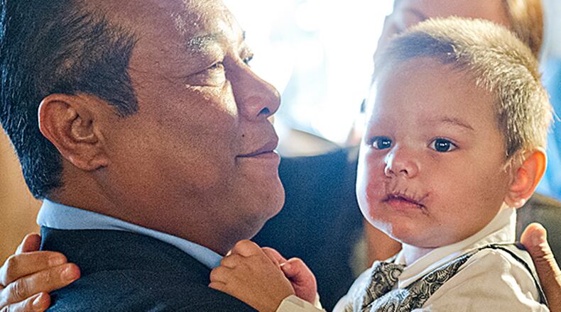 July 2, 2014 Atlanta - Bounkham Phonesavanh Sr. (left) holds his son Bounkham during a farewell breakfast at Delightful Eatz in Atlanta on Wednesday, July 2, 2014. Known as Baby Bou Bou, the young child has been in the hosital for the past five weeks after a botched drug raid in Habersham County. JONATHAN PHILLIPS / SPECIAL