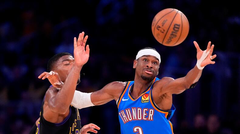 Oklahoma City Thunder guard Shai Gilgeous-Alexander, right, takes a pass while under pressure from Los Angeles Lakers forward Rui Hachimura during the first half of Game 4 in a second-round NBA basketball playoffs series Monday, May 11, 2026, in Los Angeles. (AP Photo/Mark J. Terrill)
