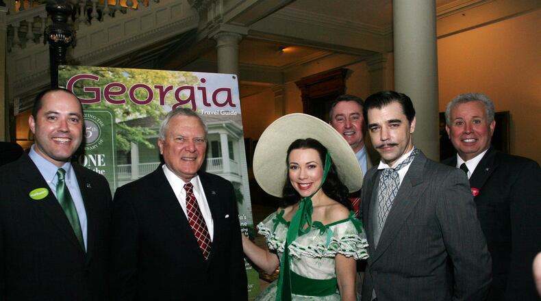 At about 9 a.m. on Tuesday, Gov. Nathan Deal attends a state Capitol ceremony to unveil Georgia’s new Gone With the Wind-themed tourism guide. Later he posed with actors portraying Scarlett O’Hara and Rhett Butler. From left to right: state Economic Development Commissioner Chris Carr, Gov. Nathan Deal. To the far right is state Rep. Ron Stephens, R-Savannah, head of the House Committee on Economic Development and Tourism. (The individual behind Scarlett O’Hara is unidentified).