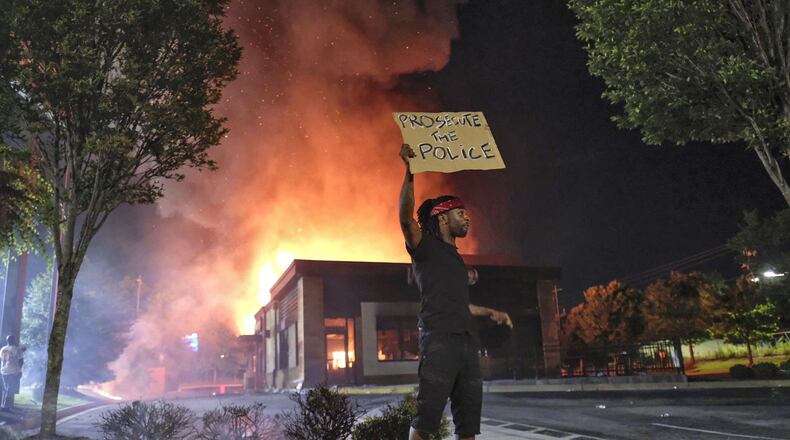 Wendy’s in flames on June 13, 2020, in southwest Atlanta after demonstrators blocked the nearby interstate and set the fast-food eatery on fire. Rayshard Brooks, a 27-year-old Black man, was shot and killed by Atlanta police the previous evening during a struggle in the Wendy’s drive-thru line. (Ben Gray for The Atlanta Journal Constitution)