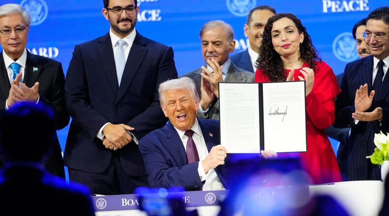 President Donald Trump holds the charter during a signing ceremony on his Board of Peace initiative at the Annual Meeting of the World Economic Forum in Davos, Switzerland, Thursday, Jan. 22, 2026. (AP Photo/Markus Schreiber)