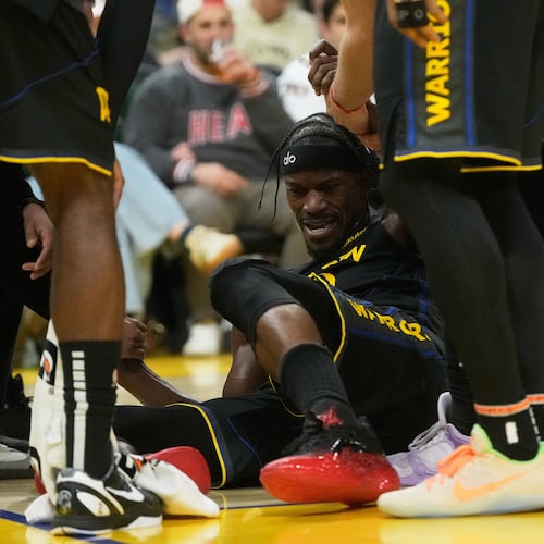 Golden State Warriors forward Jimmy Butler III, middle, is helped up by teammates during the second half of an NBA basketball game against the Miami Heat in San Francisco, Monday, Jan. 19, 2026. (AP Photo/Jeff Chiu)