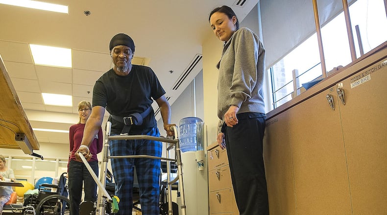 Physical therapist intern Lauren Murphy watches as Timothy Simpson uses a reacher device to place blocks atop cones at the Roosevelt Warm Springs Rehabilitation and Specialty Hospital in Warm Springs. The hospital, which started as a polio treatment center founded by Franklin Delano Roosevelt, now rehabilitates patients with a range of mobility and function disorders as part of Augusta University Health. It has settled a dispute with the federal government over Medicare payments. (PHOTO by ALYSSA POINTER/ALYSSA.POINTER@AJC.COM)