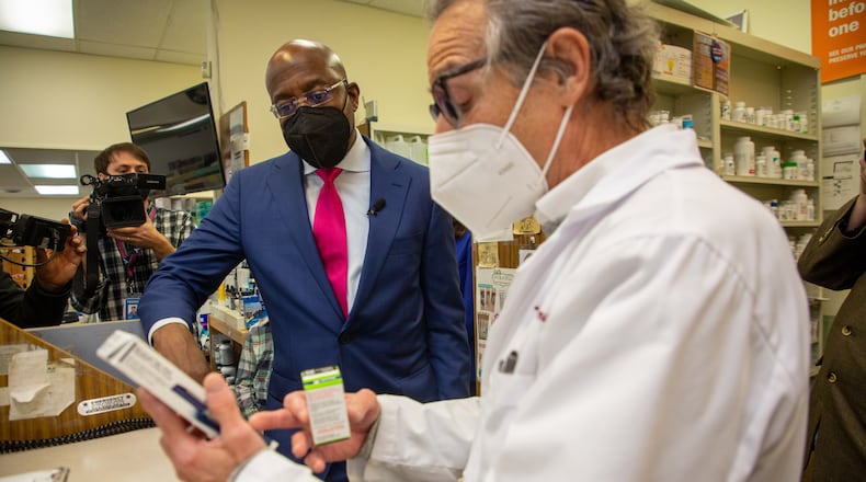 U.S. Sen. Raphael Warnock talks with pharmacist Ira Katz about his proposal to cap the price of insulin during a visit last month to the Little Five Points Pharmacy. STEVE SCHAEFER FOR THE ATLANTA JOURNAL-CONSTITUTION