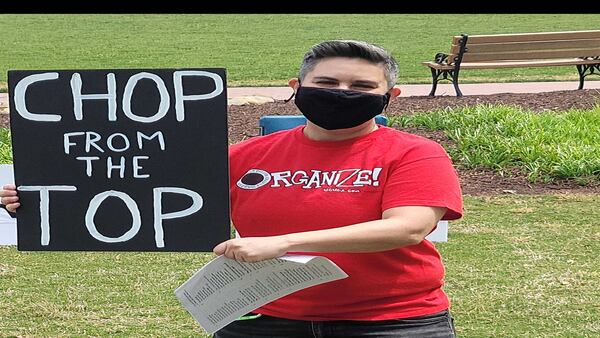 United Campus Workers of Georgia, Communications Workers of America member Sara Giordano holds a sign demanding colleges and universities "chop from the top" when making job cuts. (Contributed/)Daniel Horowitz