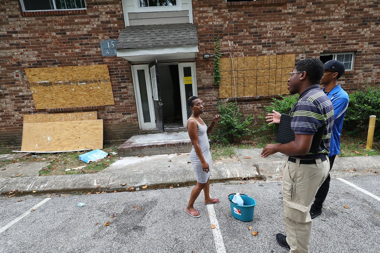 Tenant Daniel Russell (left) speaks with Atlanta zoning employees outside the burned out unit next to her apartment at the Pavilion Place apartments while code enforcement, zoning, and State Department of Community Affairs officials do a sweep on Monday, August 1, 2022, in Atlanta. An AJC investigations of dangerous apartment complexes prompted officials to promise a crackdown. “Curtis Compton / Curtis Compton@ajc.com