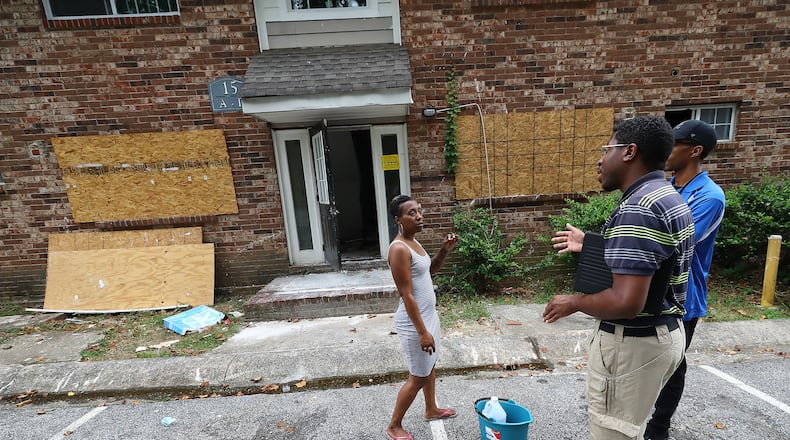 Tenant Daniel Russell (left) speaks with Atlanta zoning employees outside the burned out unit next to her apartment at the Pavilion Place apartments while code enforcement, zoning, and State Department of Community Affairs officials do a sweep on Monday, August 1, 2022, in Atlanta. An AJC investigations of dangerous apartment complexes prompted officials to promise a crackdown. “Curtis Compton / Curtis Compton@ajc.com