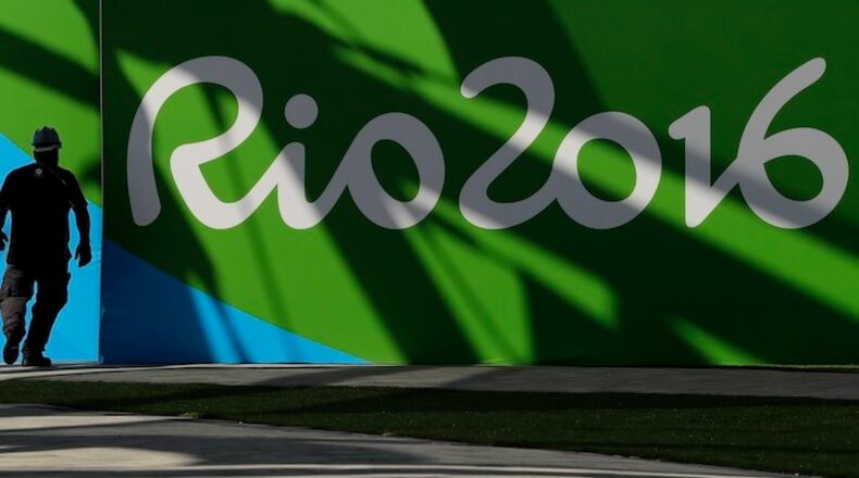A worker walks past a sign for the Rio Olympics while making preparations at Olympic Park in Rio de Janeiro, Brazil, Wednesday, July 27, 2016. (AP Photo/Charlie Riedel)