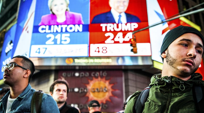 People watch election results at Times Square in New York. Now, businesses, economists and consumers will be watching to see if his promises to spur growth pan out. (George Etheredge/The New York Times)