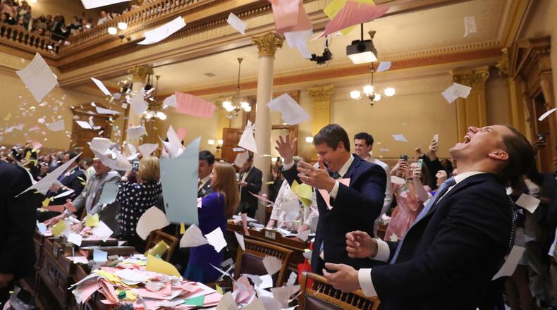 March 29, 2018 - Atlanta, Ga: Jared Williams, right, throws a large pile of paper in the air next to his father, Sen. Michael Williams, R-Cumming, left, as Sine Die was proclaimed shortly after midnight during Legislative Day 40 in the Senate Chamber at the Georgia State Capitol Thursday, March 29, 2018, in Atlanta. PHOTO / JASON GETZ