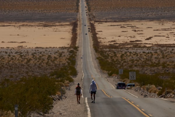 Danny Westergaard, right, competes with pacing help from daughter Meagan Westergaard during the Badwater 135 Ultramarathon, Tuesday, July 8, 2025, in Death Valley National Park, Calif. (AP Photo/John Locher)