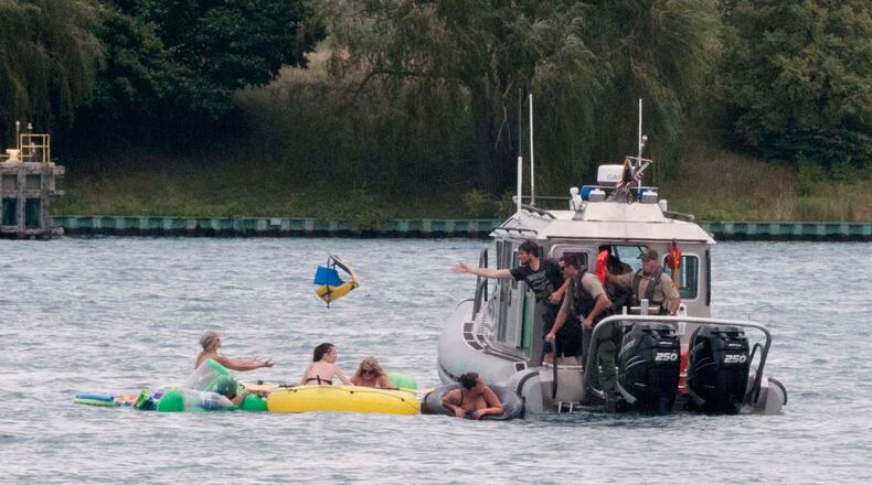 A Customs and Border Protection boat helps floaters during Float Down on the St. Clair River in Port Huron, Mich., Sunday, Aug. 21, 2016. The west winds blew most boaters toward the Canada shore and they had to be pulled back to the U.S. Thousands were expected to take part in Port Huron Float Down. (Mark R. Rummel/The Times Herald via AP)