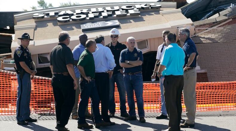 Republican vice presidential candidate, Indiana Gov. Mike Pence, talks with representatives as they stand outside of a Starbucks restaurant, Thursday, Aug. 25, 2016, in Kokomo, Ind. The restaurant was hit by a tornado that pass through the area Wednesday afternoon. (AP Photo/Darron Cummings)