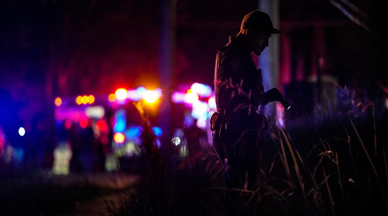 An Atlanta police officer investigates a shooting on Bolton Road. It was one of three shootings police responded to within one hour.