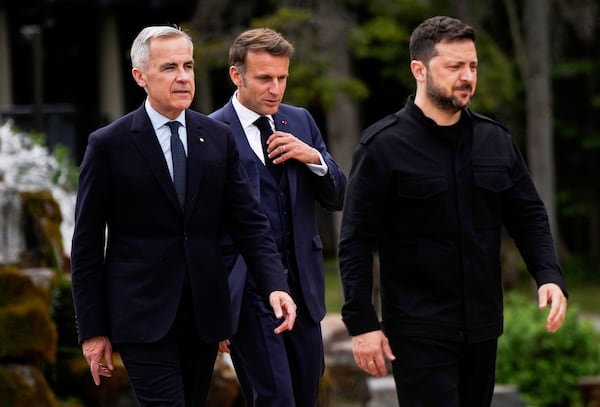 Canada's Prime Minister Mark Carney, front left, Ukrainian President Volodymyr Zelenskyy, front right, and French President Emmanuel Macron, back centre, arrive for the family photo of world leaders and invited guests at the G7 Summit in Kananaskis, Alberta, Tuesday, June 17, 2025. (Darryl Dyck/The Canadian Press via AP)