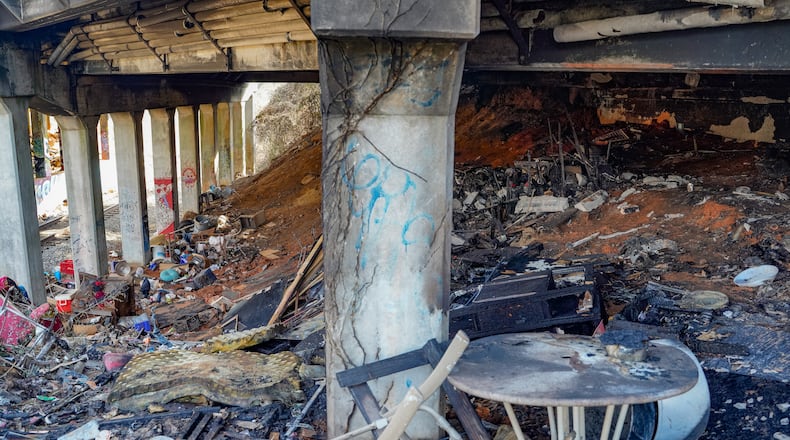 Charred items that may have been part of a homeless encampment were left after a fire off Cheshire Bridge Road early Wednesday.