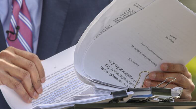 Television crews go over the Mueller report outside the U.S. Department of Justice on Thursday in Washington. Tasos Katopodis/Getty Images