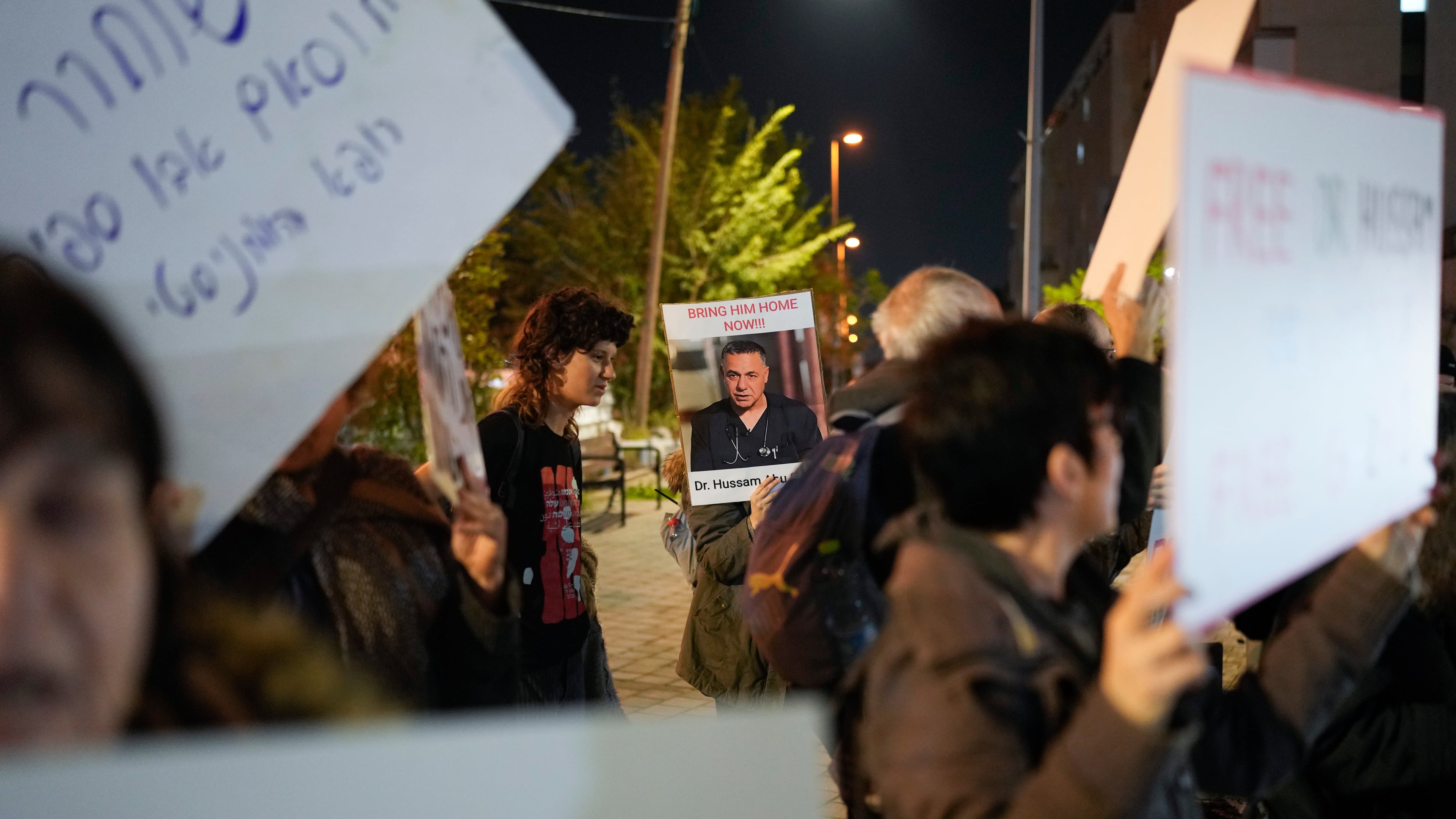 FILE - A woman holds a sign with a photo of Palestinian Dr. Hussam Abu Safiya during a protest calling for his release in front of the Shin Bet offices in Tel Aviv, Israel, Jan. 1, 2025. (AP Photo/Matias Delacroix, File)