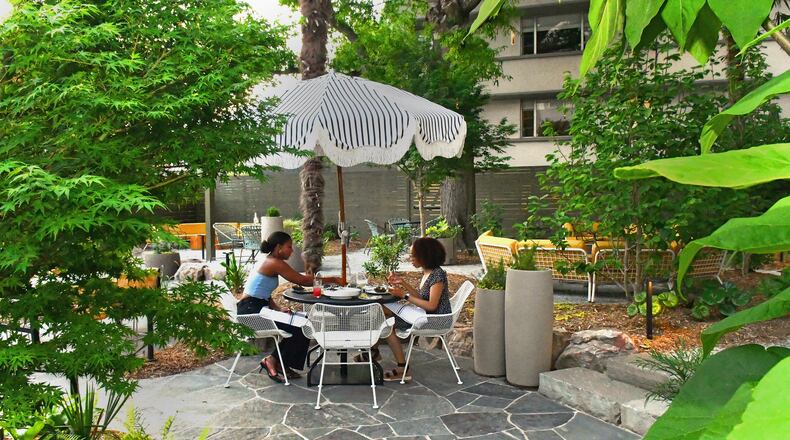 Diners enjoy a warm Tuesday evening at Willow Bar at the Kimpton Sylvan Hotel on East Paces Ferry Road in Buckhead. The open-air bar features a winding gravel path through soft seating choices underneath a canopy of old oak and palm trees. The patio area was originally a pool and gym area for the mid-century 1950's residential structure recently reimagined as a hotel. (Chris Hunt for The Atlanta Journal-Constitution)