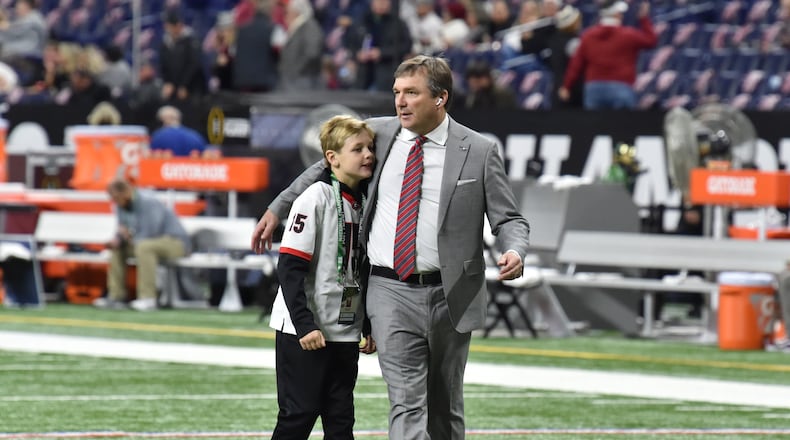 Georgia's coach Kirby Smart hugs his son his son Andrew as he walks on the football field before the 2022 College Football Playoff National Championship Game against Alabama at Lucas Oil Stadium in Indianapolis on Monday, January 10, 2022. (Hyosub Shin / Hyosub.Shin@ajc.com)