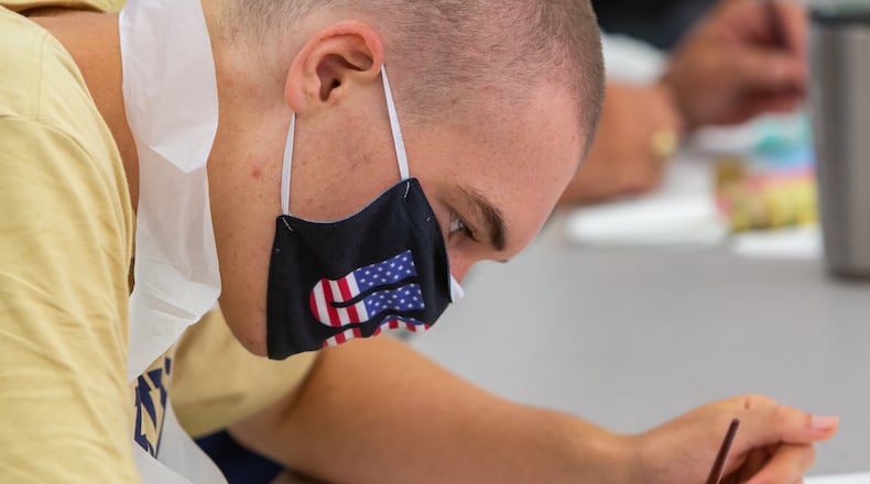 St. Pius X Catholic School football player Jimmy Brady paints "Heart Boards" to show his support & appreciation in August to healthcare worker during the pandemic.PHIL SKINNER FOR THE ATLANTA JOURNAL-CONSTITUTION.