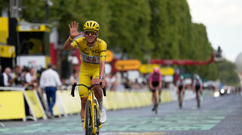 Slovenia's Tadej Pogacar, wearing the overall leader's yellow jersey, celebrates as he crosses the finish line of the last stage of the Tour de France cycling race with start and finish in Paris, Sunday, July 26, 2026. (AP Photo/Mosa'ab Elshamy)