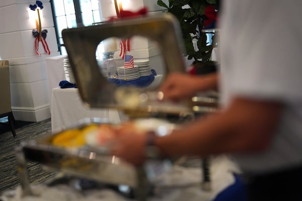 American flags decorate an Independence Day buffet service as a resident serves up food, in the independent living facility at the Toby and Leon Cooperman Sinai Residences, July 4, 2025, in Boca Raton, Fla. (AP Photo/Rebecca Blackwell)