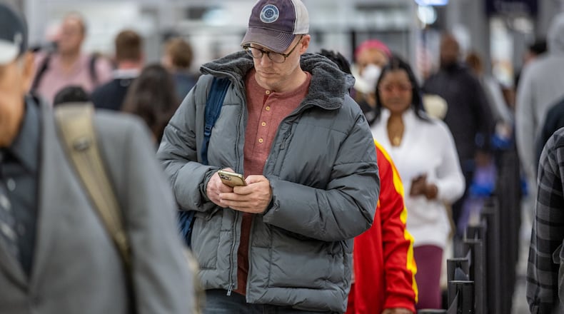 Travelers stand in line to go through the security checkpoint at Hartsfield-Jackson Atlanta International Airport during a busy Friday morning, October 28, 2022. (Steve Schaefer/steve.schaefer@ajc.com)