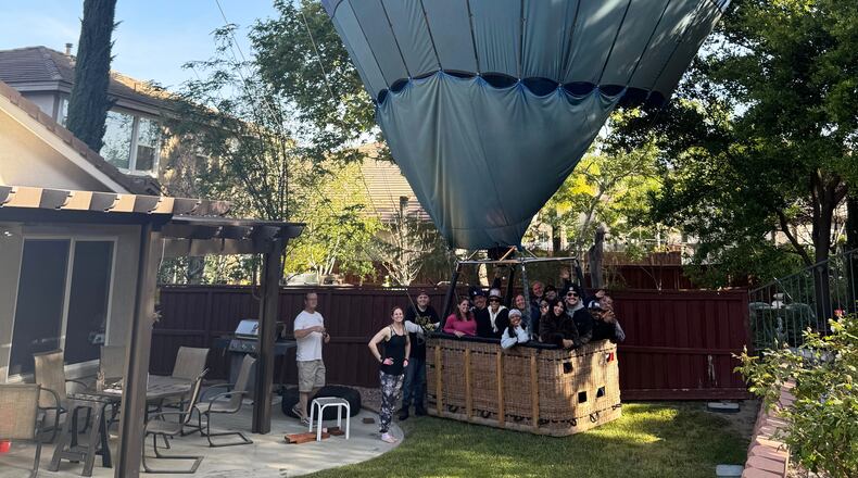 This photo provided by Hunter Perrin shows people riding a hot air balloon posing for a photo after making an emergency landing in Perrin's backyard on Saturday, April 18, 2026, in Temecula, Calif. (Hunter Perrin via AP)