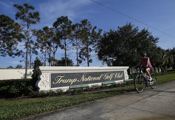A bike rides by the sign of Trump National Golf Club on Nov. 11, 2016, in Jupiter, Florida. (Yuting Jiang / The Palm Beach Post)