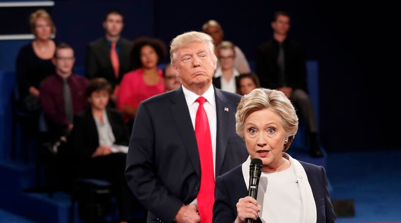 Democratic presidential nominee Hillary Clinton, right, speaks as Republican presidential nominee Donald Trump listens during the second presidential debate at Washington University in St. Louis on Oct. 9. 2016.