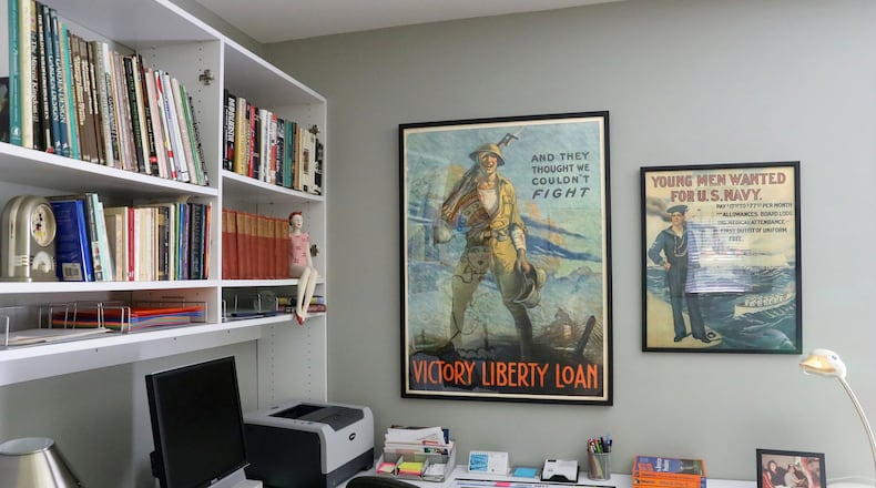 An office wall contains vintage World War II posters. The one on the right reads “Young men wanted for U.S. Navy.” The poster on the left is soliciting war loans. (Christian Gooden/St. Louis Post-Dispatch/TNS)