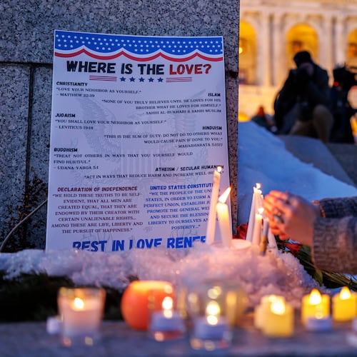Candles burn around a poem written by Renee Good during a vigil honoring her on Friday, Jan. 9, 2026, in St. Paul, Minn., outside the Minnesota State Capitol. (Kerem Yücel/Minnesota Public Radio via AP)