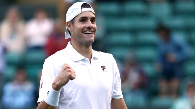 John Isner celebrates defeating Milos Raonic of Canada during their Men's Singles quarterfinals match on day nine of the Wimbledon Lawn Tennis Championships at All England Lawn Tennis and Croquet Club on July 11, 2018 in London.