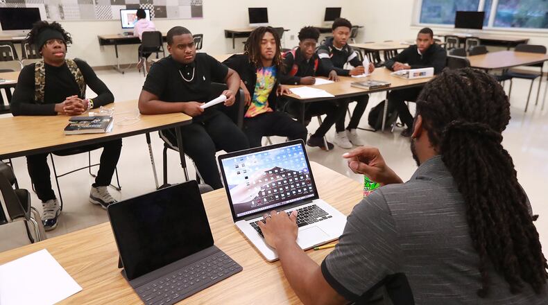 Play It Smart academic coach Matthew Hazel helps Therrell High School student athletes from the football team register for the online NCAA Clearinghouse, a requirement to become eligible to play college sports. The academic coach meets with the students after school on Monday, Dec. 16, 2019, in Atlanta. CURTIS COMPTON/CCOMPTON@AJC.COM