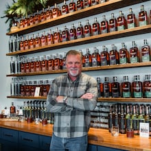 Jeff Arnett stands among bottles of Company Distilling whiskey, the brand he helped build as part of his second act in the spirits industry. (Courtesy of Leonard Garrison)