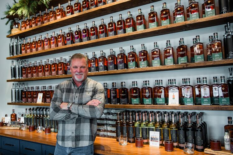 Jeff Arnett stands among bottles of Company Distilling whiskey, the brand he helped build as part of his second act in the spirits industry. (Courtesy of Leonard Garrison)