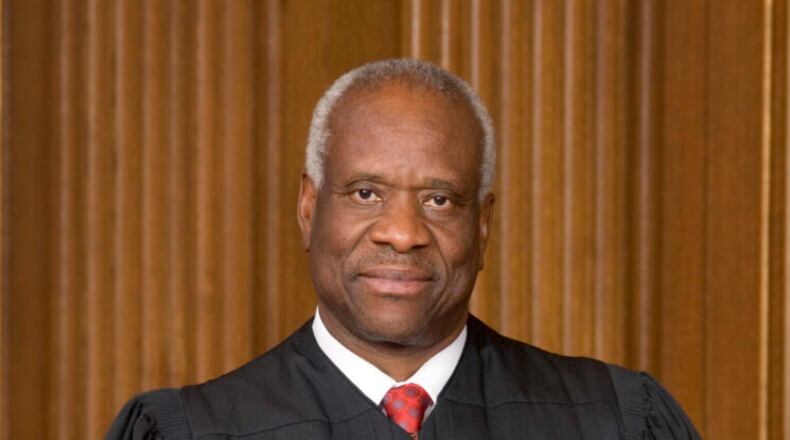black man with short grey hair with black judge gown and red tie.