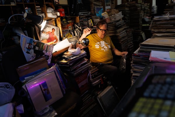 Wax ’n’ Facts owner Danny Beard places vinyls in sleeves behind the checkout counter on Saturday, July 11, 2026 in Atlanta. (Estela Muñoz/AJC)
