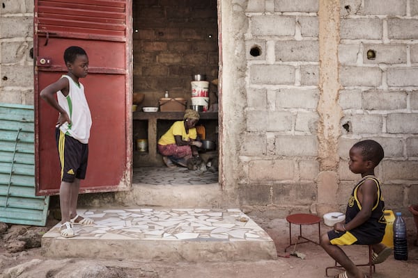 Children sit nearby as Sadio Camara, a gold processor, vaporizes mercury to separate and retrieve gold at her home in the Kedougou region of Senegal on Thursday, Jan. 16, 2025. (AP Photo/Annika Hammerschlag)
