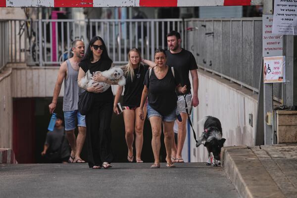People leave an underground parking garage where they took shelter after an air raid alarm of Iranian missile attacks went off, in Tel Aviv, Israel, Tuesday, June 24, 2025. (AP Photo/Ohad Zwigenberg)