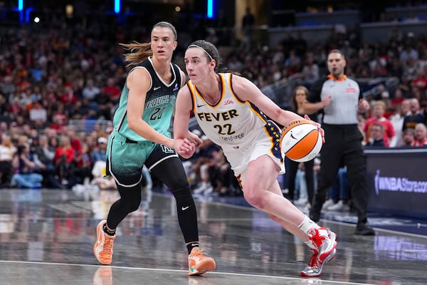 Indiana Fever guard Caitlin Clark (22) drives on New York Liberty guard Sabrina Ionescu (20) in the second half of a WNBA basketball game in Indianapolis, Saturday, May 24, 2025. (AP Photo/Michael Conroy)