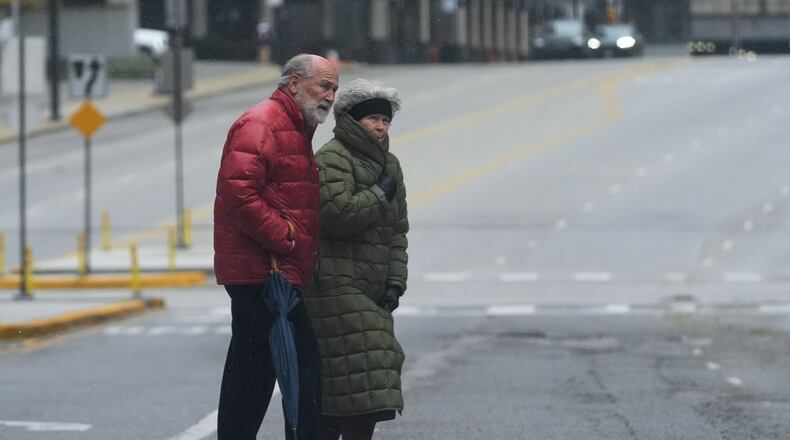 Pedestrians cross a street during a cold day in Chicago, Sunday, Nov. 9, 2025. (AP Photo/Nam Y. Huh)