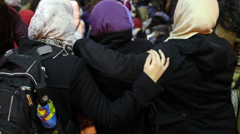 Three Muslim women embrace during a prayer earlier this year in Centennial Olympic Park while at a vigil in remembrance of the three Muslim students killed in North Carolina. The Islamic Speakers Bureau of Atlanta is sponsoring a workshop today for Muslim middle and high school students on handling situations in which they or the Islamic faith is attacked. BEN GRAY / BGRAY@AJC.COM
