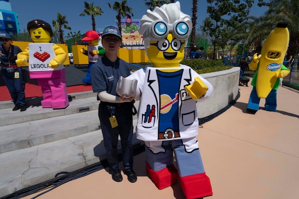Workers guide Lego mascot characters during the opening of Legoland Shanghai, China's first and the world's largest Legoland resort, in Shanghai, Saturday, July 5, 2025. (AP Photo/Ng Han Guan)